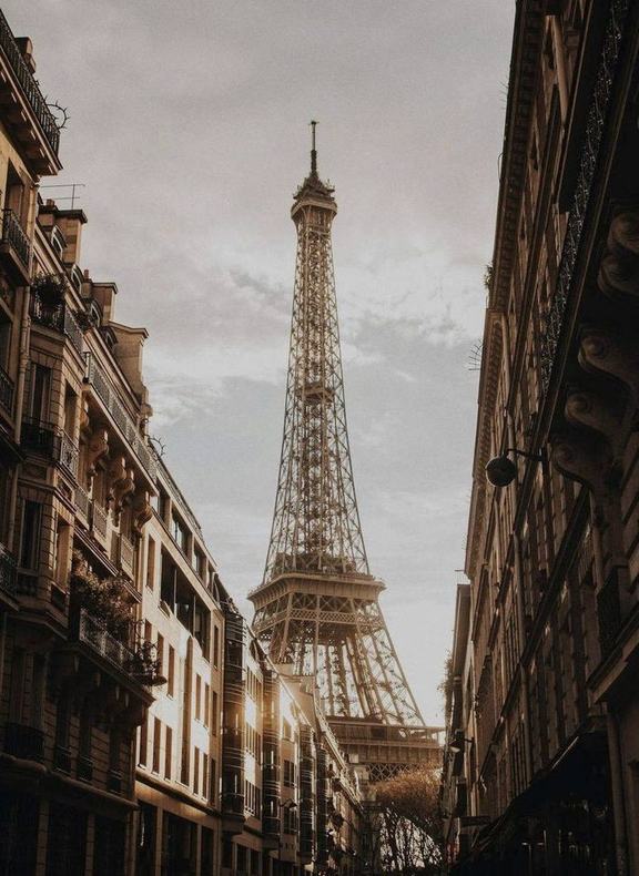 The Eiffel Tower at the end of a Paris street in evening light