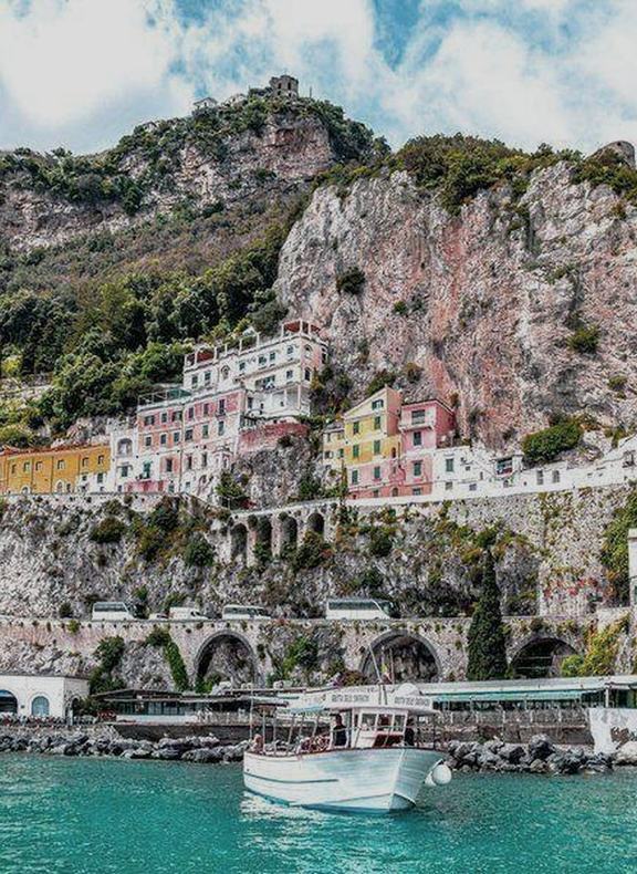 A pastel cliffside village on the Amalfi Coast, a boat in the foreground