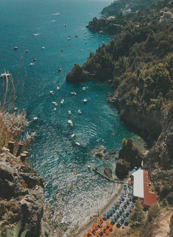 A cove and beach clubs beneath the cliffs of the Amalfi Coast